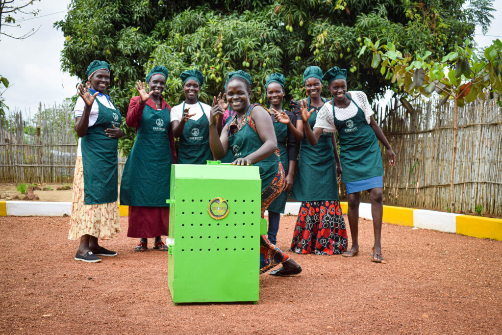 women in Uganda gathered around a sparky dryer